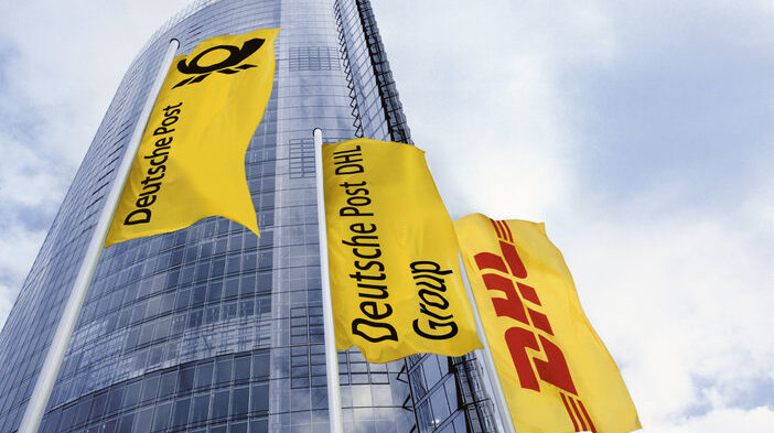 DHL company logo on three yellow flags outside a tall company office building