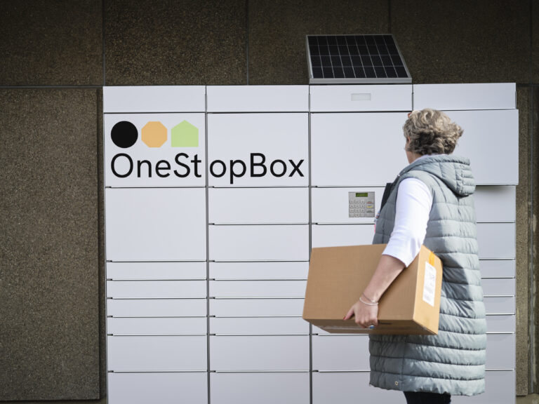 Female customer using the OneStopBox parcel locker to send a parcel