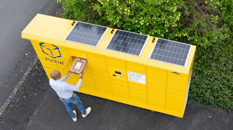 Man posting a parcel into a yellow Pickup locker with solar panels on the top.