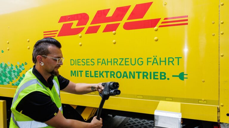 E.ON to provide charging infrastructure for DHL electric trucks Man plugging in electric charging to DHL branded van.