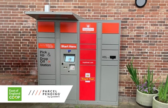 Grey and orange Parcel Pending by Quadient parcel locker outside Framlingston Co-Op, in front of brick wall