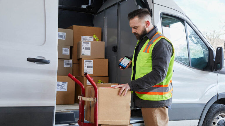 Delivery driver using handheld device to scan parcel