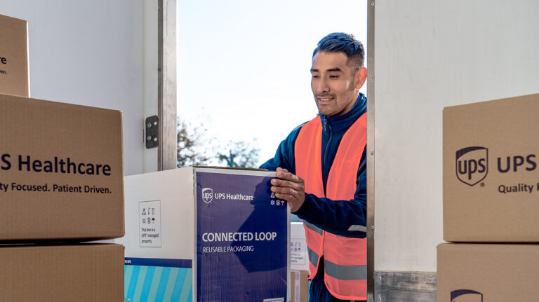 A UPS Healthcare worker picks up a box.
