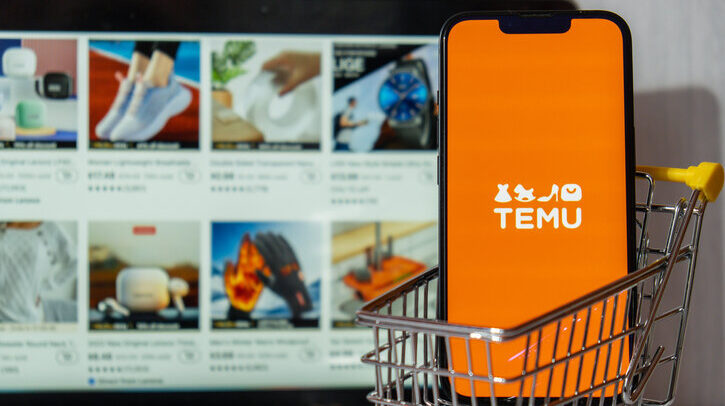 Gdansk, Poland - March 2023 Temu app icon in screen of MacBook Apple computer laptop and mobile Iphone with shopping cart. Temu subsidiary of China based e-commerce platform Pinduoduo. Online shopping Temu website