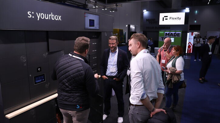 Exhibitors and visitors talk on the show floor at Parcel+Post Expo.