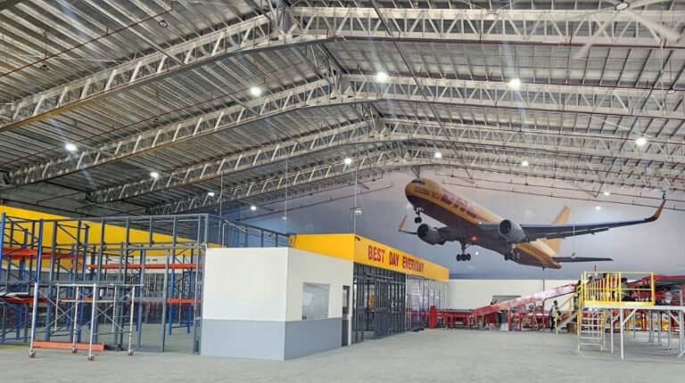 The interior of the relocated and expanded Cebu Gateway in the Philippines, with sorting equipment in the foreground and a painting of a DHL cargo plane on the far wall