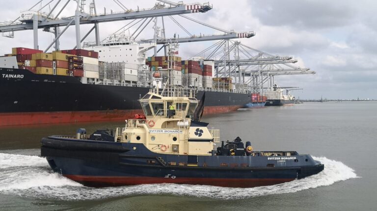 Svitzer's Monarch tugboat alongside a contained ship at port on a grey sea under a cloudy sky