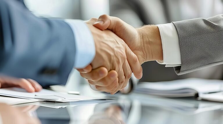 Two men shake hands after completing a business deal