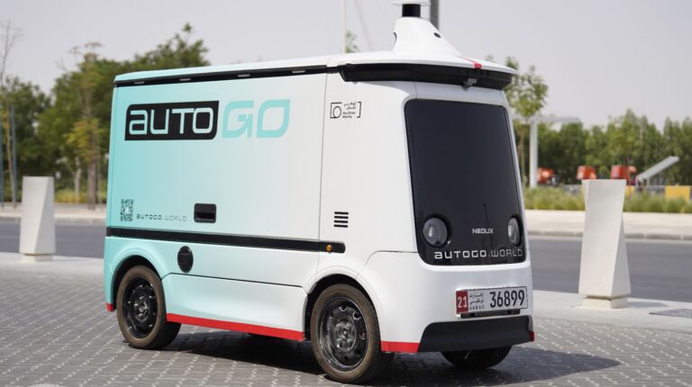 An AutoGo autonomous delivery vehicle drives down a quiet urban street