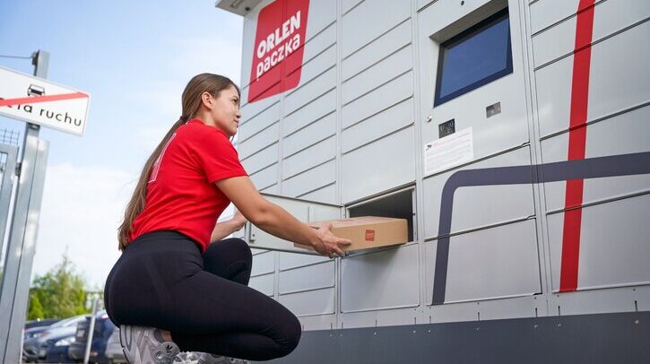 A Poczta Polska team member delivers a package to a parcel locker