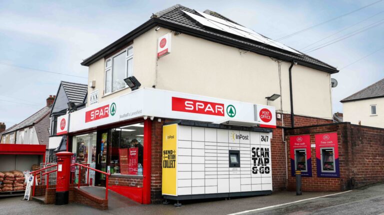 inPost lockers outside a Post Office location at the corner of two roads, with Spar signage on the store behind them.