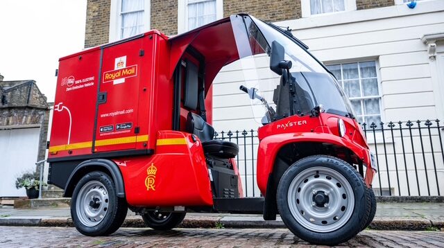 A Royal Mail micro electric vehicle from Paxster, with red livery, parked at the side of the road of a residential street.