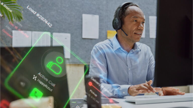A worker sits at a desk in front of a screen and keyboard with a telephone headset on, with digital imagery superimposed demonstrating how HappRobot AI Agents can assist their work