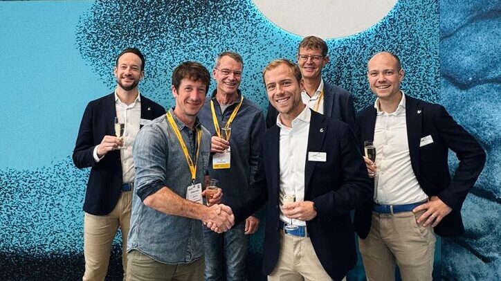 The Swiss Post and EAE Solutions teams shaking hands on the sorter deal at Parcel+Post Expo