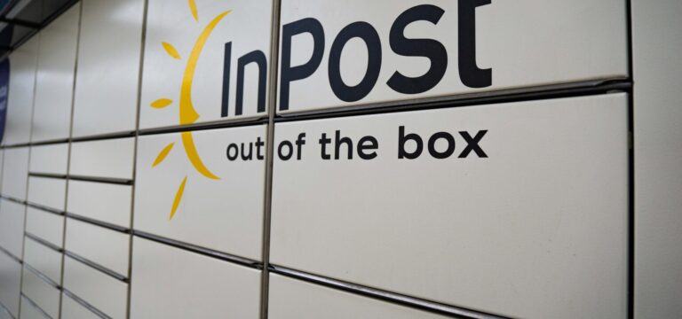 A bank of grey InPost lockers with the company logo on the outside.